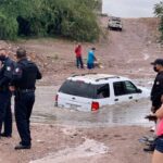 Rescatan a familia varada por intentar cruzar arroyo en camioneta